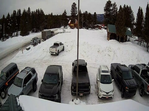 Snow banks piled higher than parked pickup trucks at the Island Park webcam in Idaho