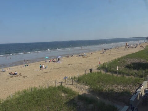 Sunbathers and umbrellas on the wide sand at Old Orchard Beach Maine on webcam