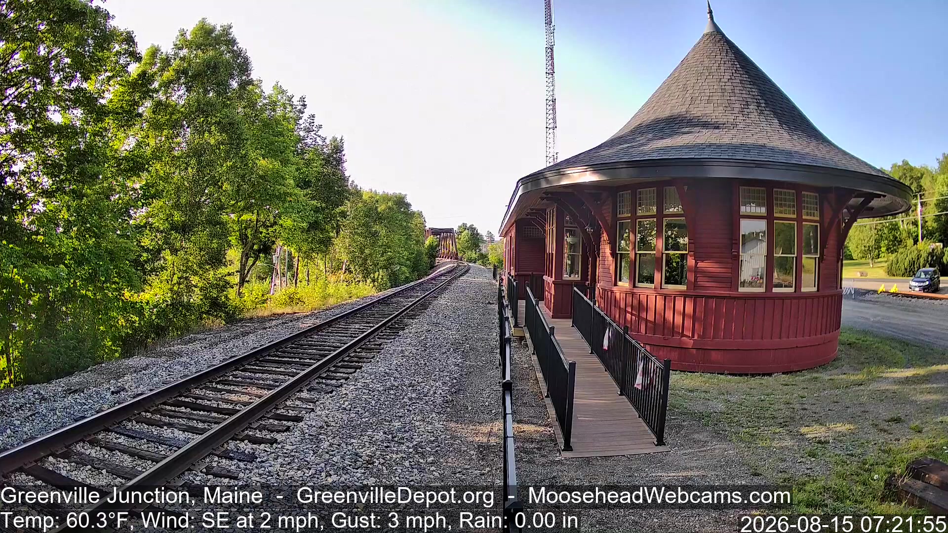 The red Greenville Junction depot and single track beside Moosehead Lake, Maine, on the live cam