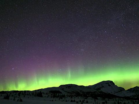 Green and purple aurora band above the ridge on the Banff Sunshine Village webcam